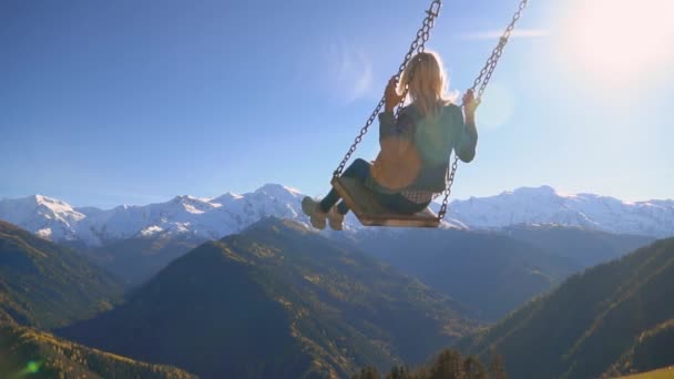 Woman rides on large swing against background of mountains in Georgia, — Stock Video