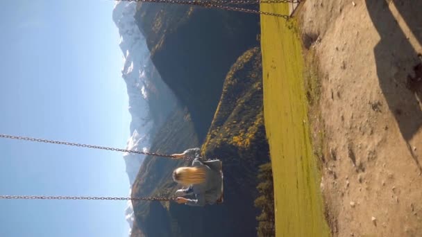 Femme balade sur une grande balançoire sur fond de montagnes en Géorgie, — Video
