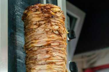 Paslanmaz çelik bir makinenin yakın çekimi yavaş yavaş sulu tavuk katmanlarını ızgarada tükürük içinde, tipik et bir sandviçte servis edilir, kebap shawarma