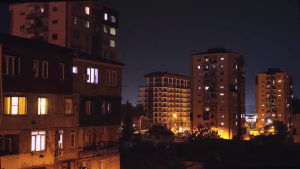 Éjszakai időeltolódás, kilátással a házakra, az ablakok fényekkel világítanak.. — Stock videók