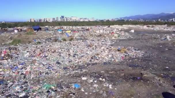 Вид дрона на міський смітник на тлі моря, міста та гір . — стокове відео