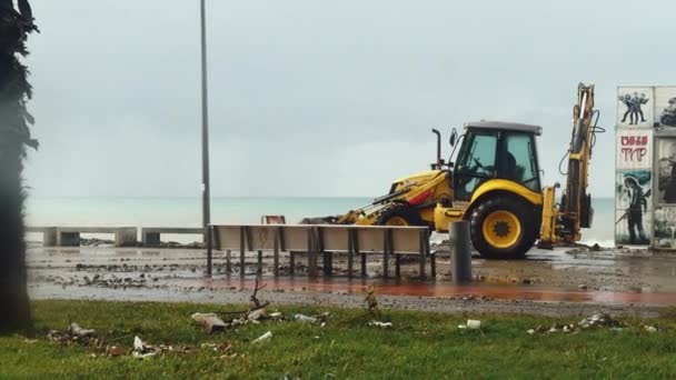 Tractor removes the effects of a storm on the embankment. — Stock Video