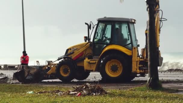 Трактор снимает воздействие шторма на насыпь. — стоковое видео