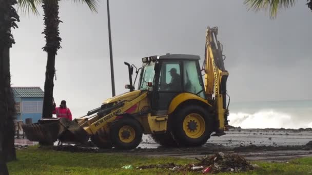 Tractor elimina los efectos de una tormenta en el terraplén. — Vídeo de stock