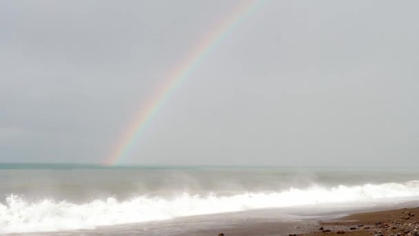 Vagues fortes sur la mer ou l'océan. arc-en-ciel apparaît à l'horizon après la tempête et la pluie. — Video