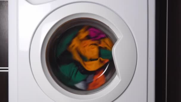 Close-up of a washing machine washing colored clothes. — Stock Video