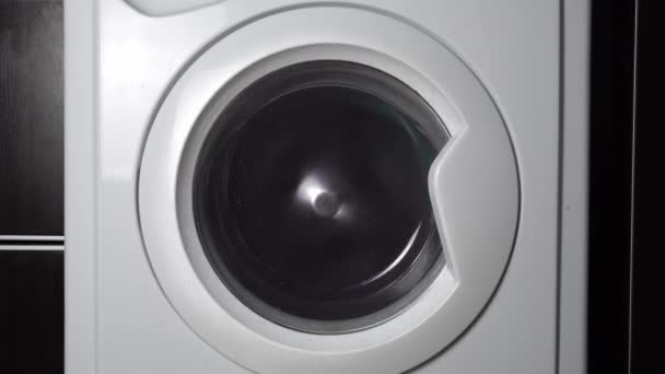 Close-up of a washing machine washing colored clothes. — Stockvideo