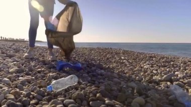 Bir kadın gönüllü siyah bir çöp torbasında çöp topluyor..