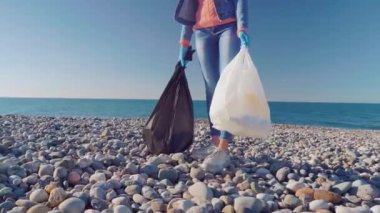 Bir kadın gönüllü siyah bir çöp torbasında çöp topluyor..