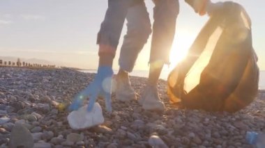 Bir kadın gönüllü siyah bir çöp torbasında çöp topluyor..