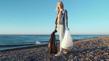 Plajda plastik şişe toplayan bir kadın.,