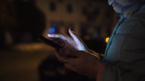 Vrouw maakt gebruik van smartphone in de nacht stad tegen politie auto met knipperende lichten. — Stockvideo