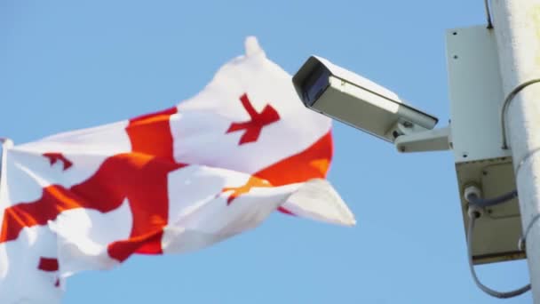 Caméra vidéo suspendue sur un poteau, drapeau géorgien — Video