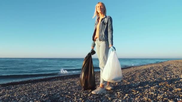En kvinna samla rengöring plastflaskor på stranden, — Stockvideo