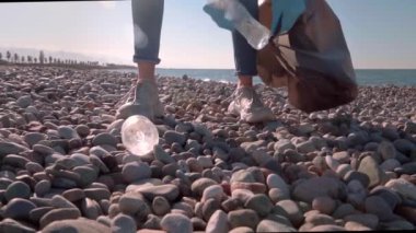 Bir kadın gönüllü siyah bir çöp torbasında çöp topluyor..