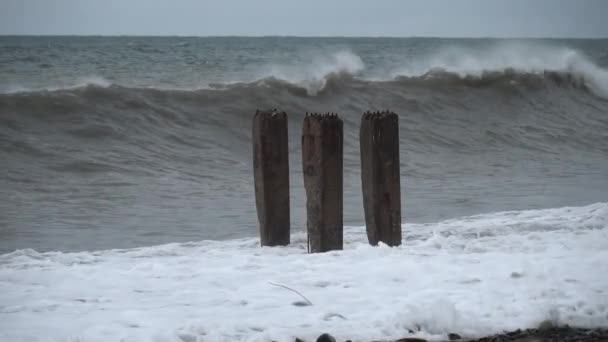 Storm waves crash against old reinforced concrete pillars on the beach — Vídeo de Stock