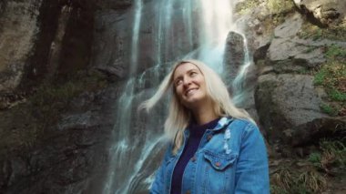 Genç bir gezgin kameraya gülümsedi ve şelaleli vahşi hayatın tadını çıkardı.