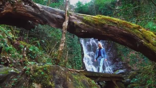 Femme marche sur un pont en bois sur fond de chute Mirveti en Géorgie. — Video