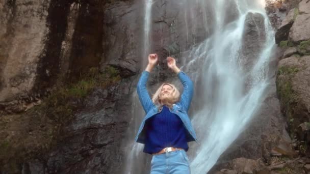 Un joven viajero sonrió a la cámara y disfrutó de la vida silvestre con una cascada — Vídeos de Stock