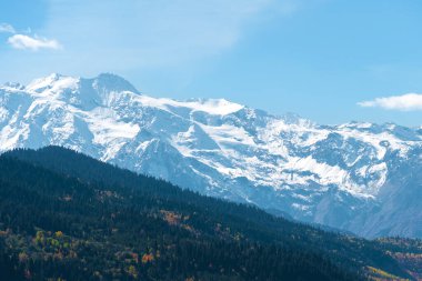 Güzel dağ manzarası, güneşli bir sonbahar günü renkli ağaçlar ve etkileyici kar zirveleri. Kafkasya dağlarının resimli manzaraları, Svaneti, Georgia