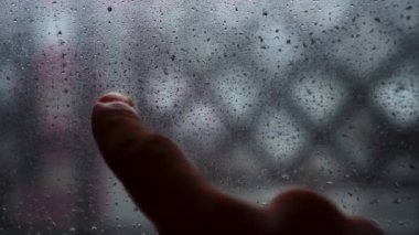 Handwritten drawing of a sad smile on frosted fogged glass.