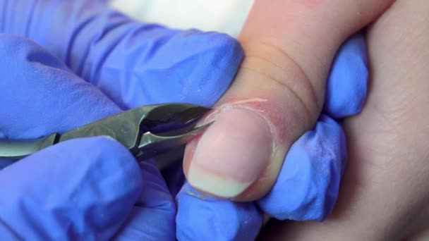 Close-up of manicure master doing a manicure to woman, cutting off the cuticle – Stock-video