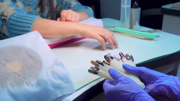 Manicure master shows color palette of client's choice for applying gel polish. — Stockvideo