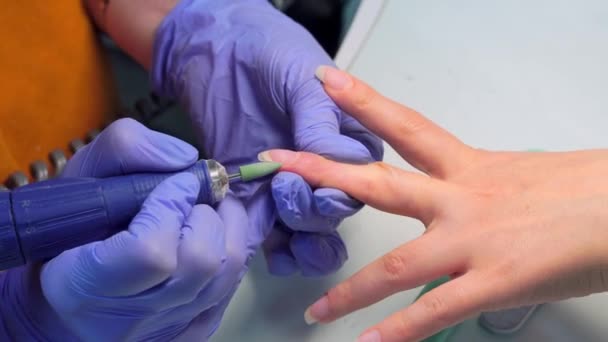 Μανικιούρ master αλέθει τα νύχια με μια ειδική συσκευή πριν από την επίστρωση βερνίκι τζελ — Αρχείο Βίντεο