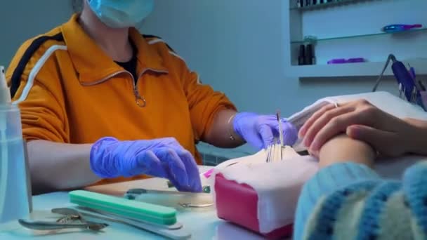 Maestro de manicura muestra la paleta de colores de la elección del cliente para la aplicación de gel polaco. — Vídeos de Stock