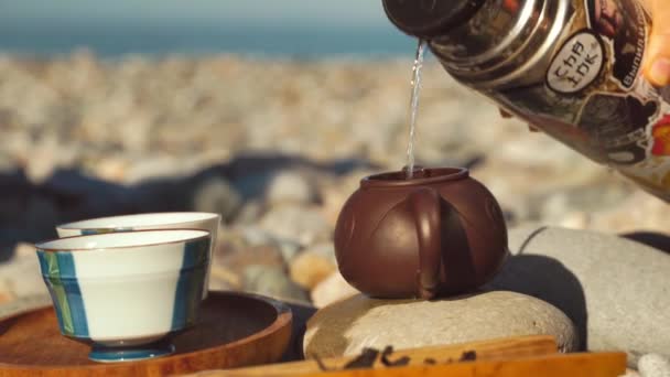 The process of brewing tea. Chinese ceremony on a pebble beach. — Vídeo de Stock