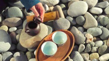 The process of brewing tea. Chinese ceremony on a pebble beach.