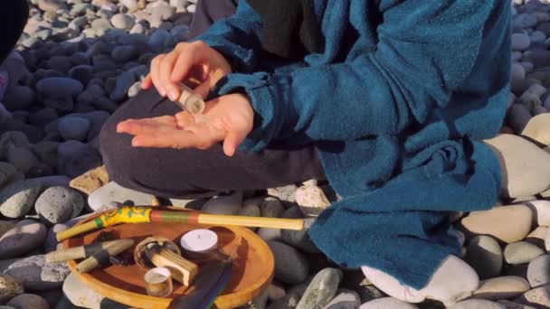 Rape ceremony, a candle tray and powder on a stone. — Stock Video