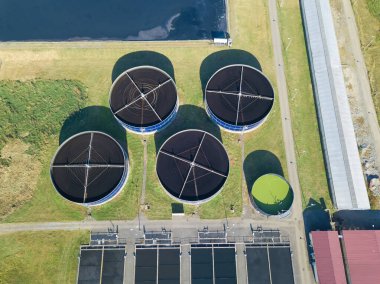 Kanalizasyon arıtma tesislerinin drone görüntüsü, kirli ya da atık su filtresi. Birincil ifade verme aşaması, atık su mekanik kazıyıcılarla büyük yuvarlak tanklardan geçiyor.