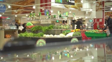 Koronavirüs salgını sırasında maskeli insanlar süpermarket raflarından ürün seçerler.