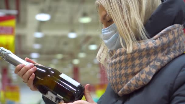 Vrouw kiest champagne of wijn in de supermarkt. Winkelen in de winkel. — Stockvideo