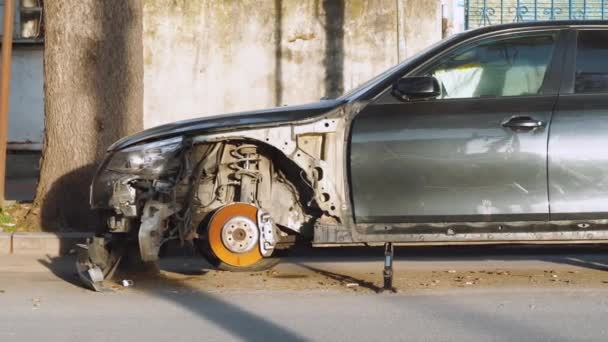Un coche desmontado abandonado está de pie a un lado de la carretera en el centro de la ciudad. — Vídeos de Stock
