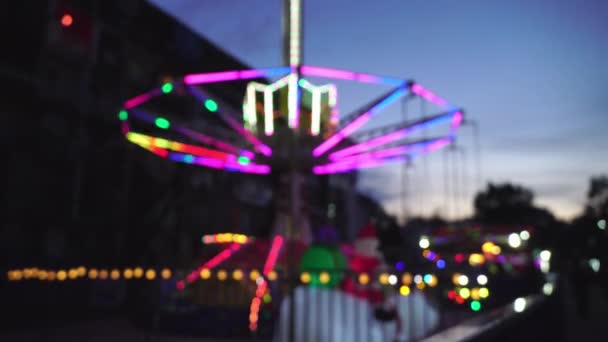 Een ongerichte retro-verlichte draaiende draaimolen in een pretpark. — Stockvideo