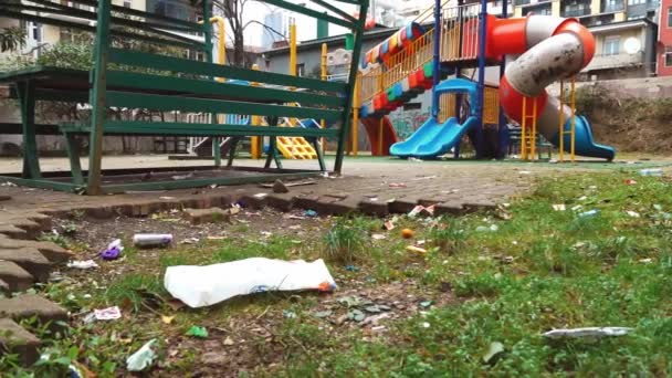 Um parque infantil no qual uma pilha de lixo está espalhada. — Vídeo de Stock