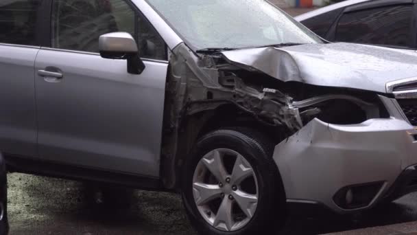 Uszkodzony samochód jest zaparkowany na ulicy miasta w pobliżu drogi. — Wideo stockowe