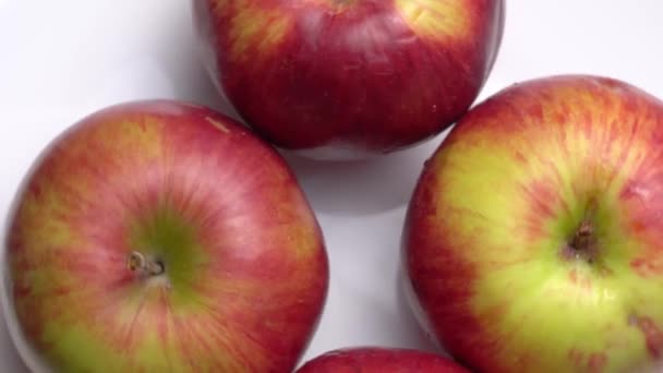 Свіжі солодкі червоні яблука обертаються на тарілці на чорному тлі . — стокове відео