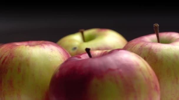 Verse zoete rode appels draaien op een bord op een zwarte achtergrond. — Stockvideo