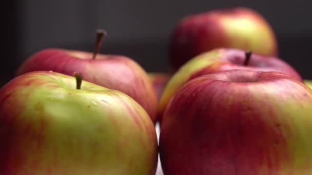 黒を基調としたプレートの上に、新鮮な甘い赤いリンゴが回っています。. — ストック動画
