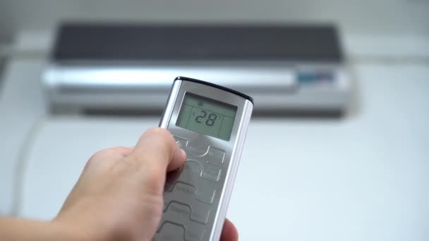 Το χέρι πιέζοντας το τηλεχειριστήριο μειώνει τη θερμοκρασία του κλιματιστικού. — Αρχείο Βίντεο