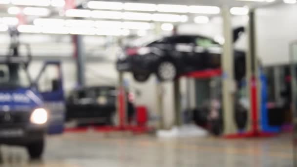Erhöhte Auto in professionellen Service-Reparatur-Prozess, unfokussierte Hintergrund. — Stockvideo