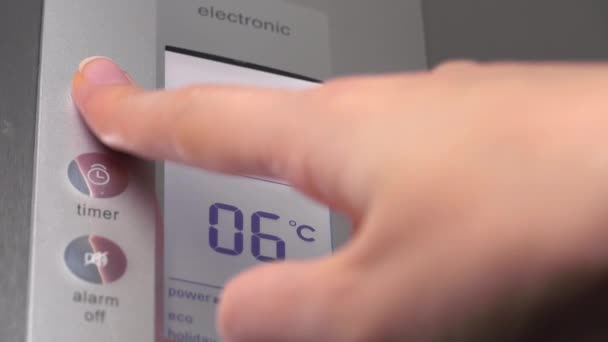 Eine Frauenhand drückt Knöpfe im Kühlschrank, um die Temperatur zu senken. — Stockvideo