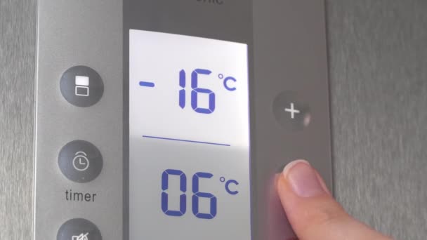 女性の手は、温度を下げる冷蔵庫のボタンを押す. — ストック動画