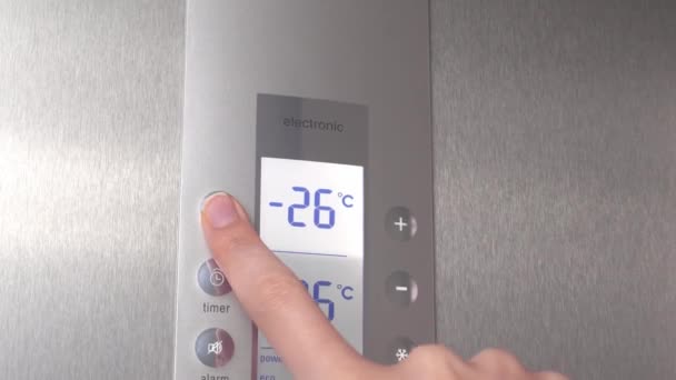 Eine Frauenhand drückt Knöpfe im Kühlschrank, um die Temperatur zu senken. — Stockvideo