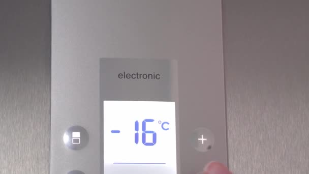Eine Frauenhand drückt Knöpfe im Kühlschrank, um die Temperatur zu senken. — Stockvideo