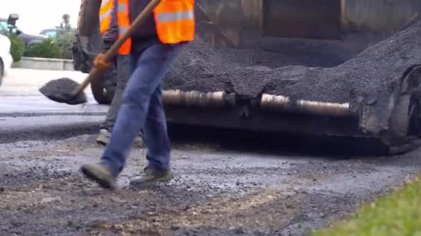 Μια ομάδα εργατών βάζει καυτή άσφαλτο στις ράγες ενός δρόμου. — Αρχείο Βίντεο