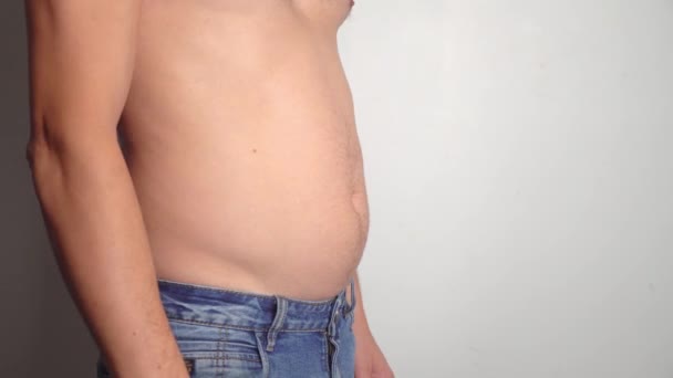 Мужской живот, лишний вес. Мужчина с голой живот трясет жировыми складками на животе — стоковое видео